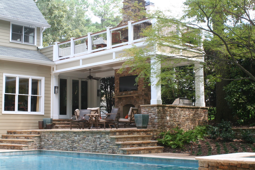 Esempio di una grande piscina classica rettangolare dietro casa con una vasca idromassaggio e pavimentazioni in pietra naturale