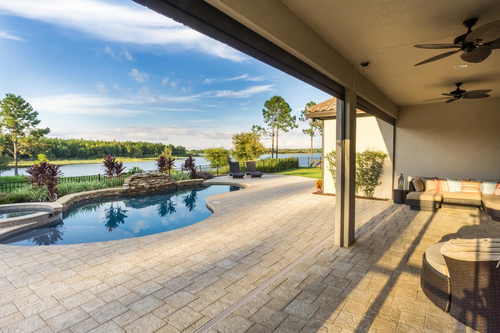 Foto di una piscina personalizzata di medie dimensioni e dietro casa con fontane e pavimentazioni in mattoni