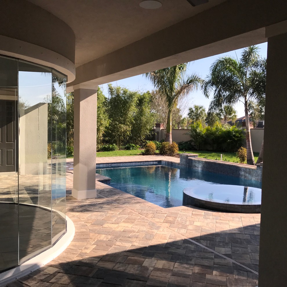 Ispirazione per una piscina monocorsia mediterranea rettangolare di medie dimensioni e dietro casa con una vasca idromassaggio e pavimentazioni in cemento