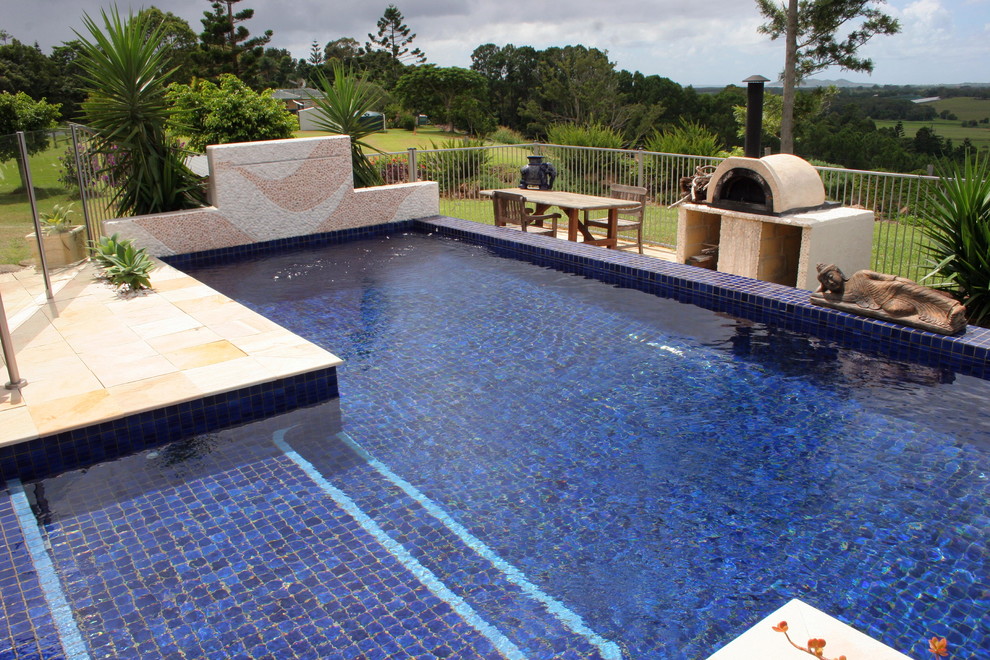 Ispirazione per una grande piscina fuori terra minimal personalizzata dietro casa con pavimentazioni in pietra naturale