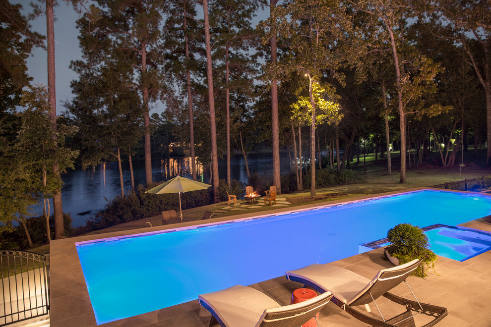 Immagine di una grande piscina monocorsia design rettangolare dietro casa con una vasca idromassaggio e piastrelle
