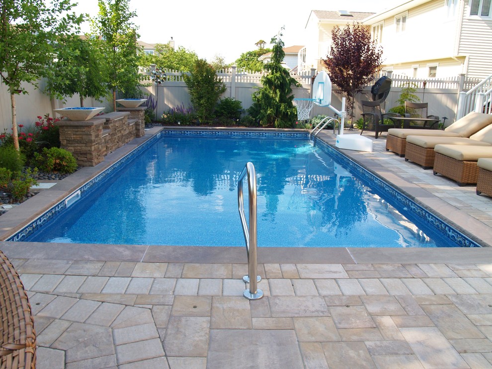 Esempio di una piscina classica rettangolare dietro casa e di medie dimensioni con fontane e pavimentazioni in cemento