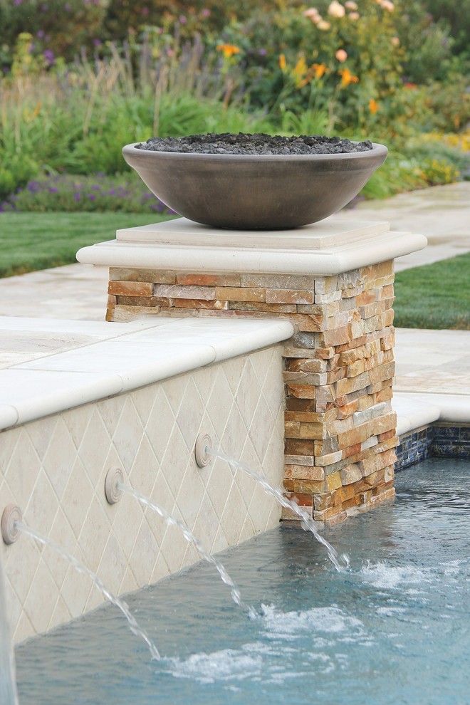 Diseño de piscina alargada rectangular en patio trasero con adoquines de piedra natural