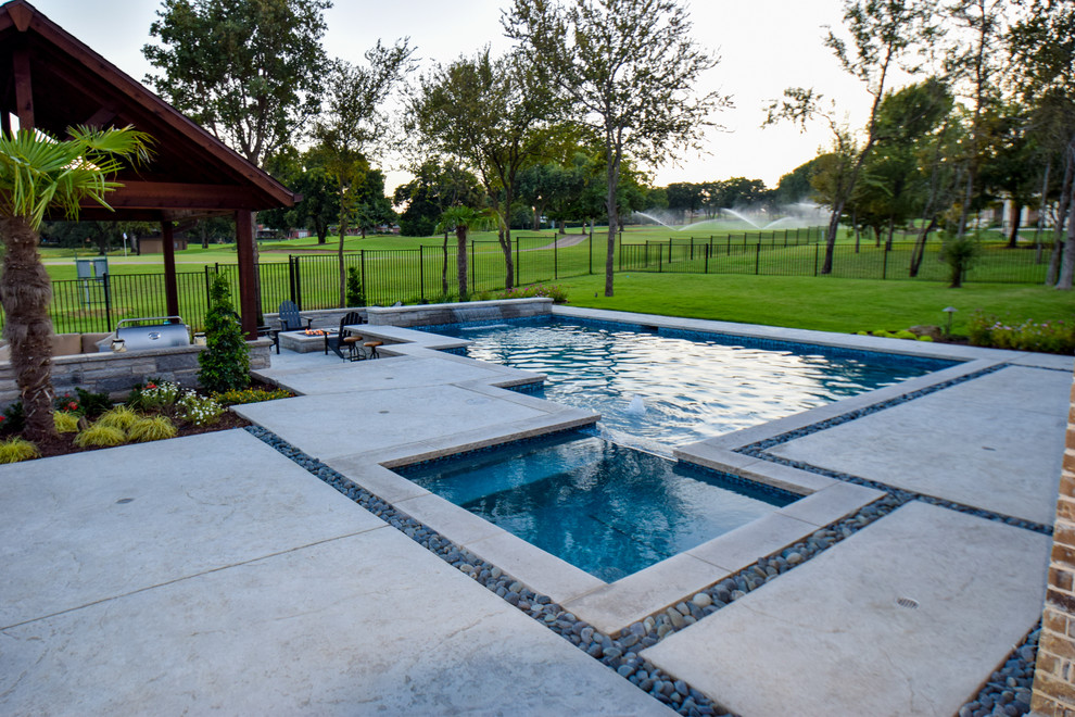 Foto di una grande piscina minimal personalizzata dietro casa con fontane e pavimentazioni in cemento
