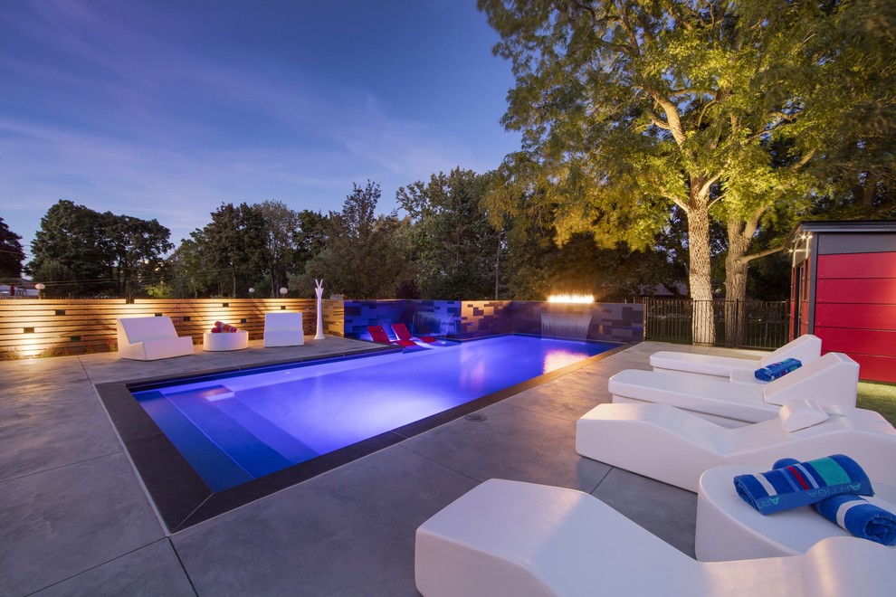Пример оригинального дизайна: спортивный, прямоугольный бассейн среднего размера на заднем дворе в стиле модернизм с домиком у бассейна и покрытием из декоративного бетона
