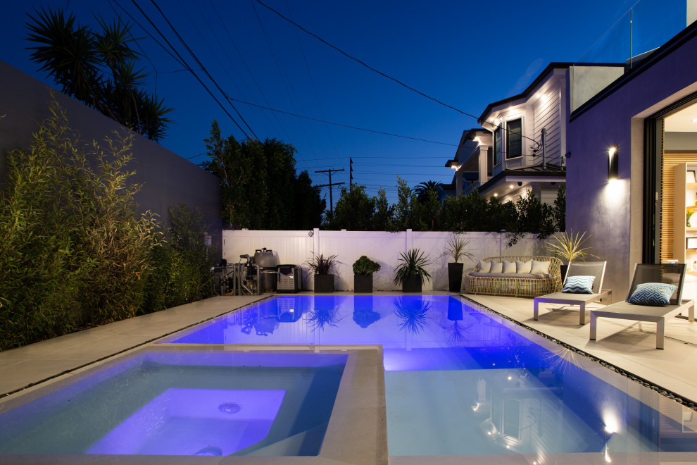 Exemple d'une grande piscine arrière moderne rectangle avec un bain bouillonnant, des solutions pour vis-à-vis et une dalle de béton.