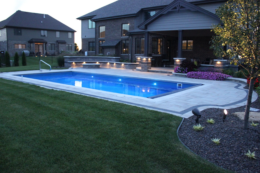 Immagine di una piscina moderna rettangolare dietro casa con fontane e pavimentazioni in mattoni