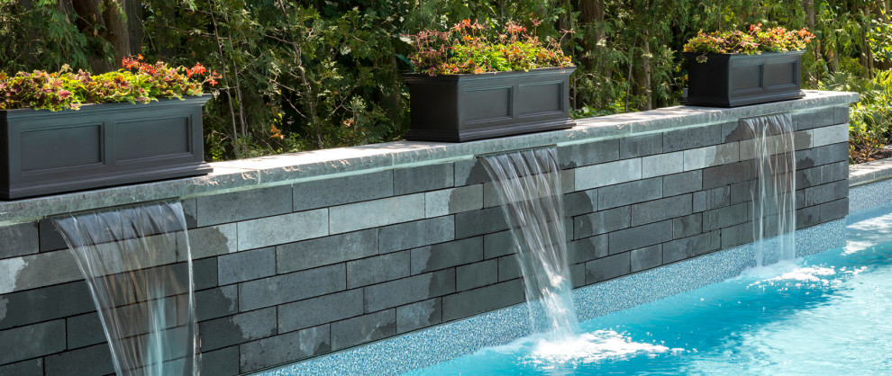 Idee per una piscina minimalista rettangolare dietro casa con fontane e pavimentazioni in cemento