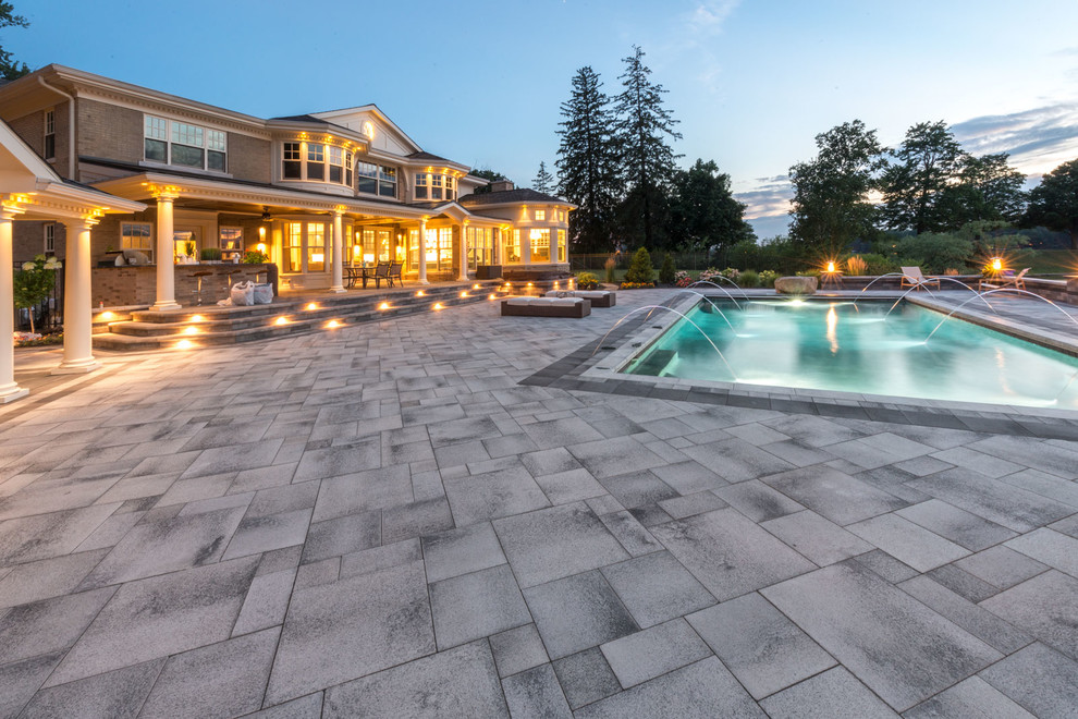 Foto di una grande piscina monocorsia tradizionale rettangolare dietro casa con pavimentazioni in cemento