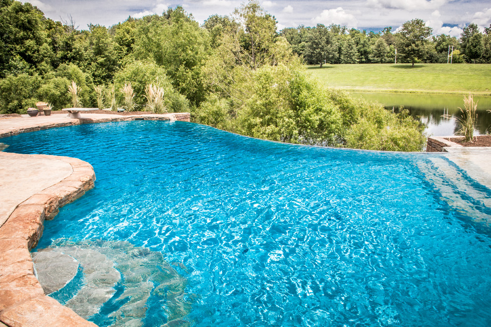 Pool fountain - large tropical backyard stamped concrete and custom-shaped natural pool fountain idea in Chicago