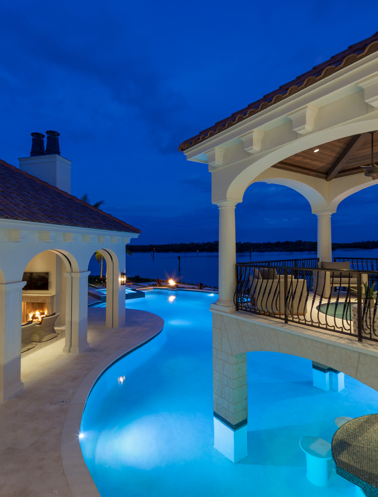 Large backyard custom-shaped infinity pool house photo in Miami