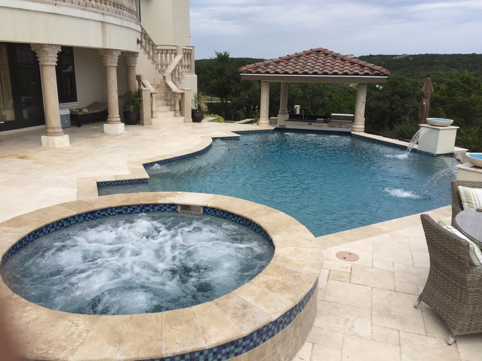 Esempio di una piscina a sfioro infinito mediterranea personalizzata di medie dimensioni e dietro casa con una vasca idromassaggio e pavimentazioni in pietra naturale