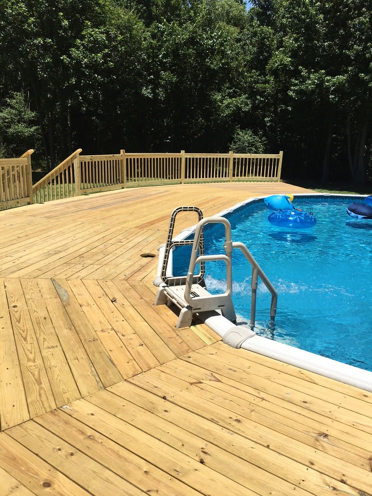 Exemple d'une piscine hors-sol et arrière chic de taille moyenne et ronde avec une terrasse en bois.