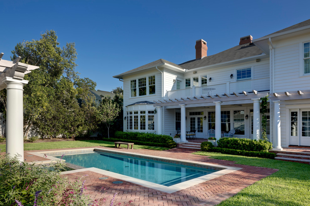 На фото: прямоугольный бассейн среднего размера на заднем дворе в классическом стиле с мощением клинкерной брусчаткой