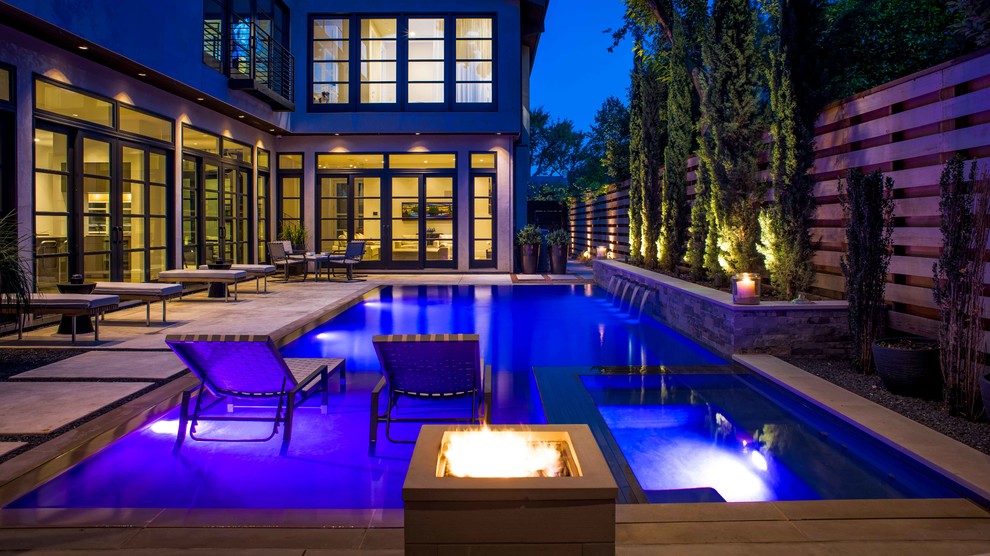 Photo of a medium sized modern courtyard rectangular infinity swimming pool in Dallas with a pool house and decking.