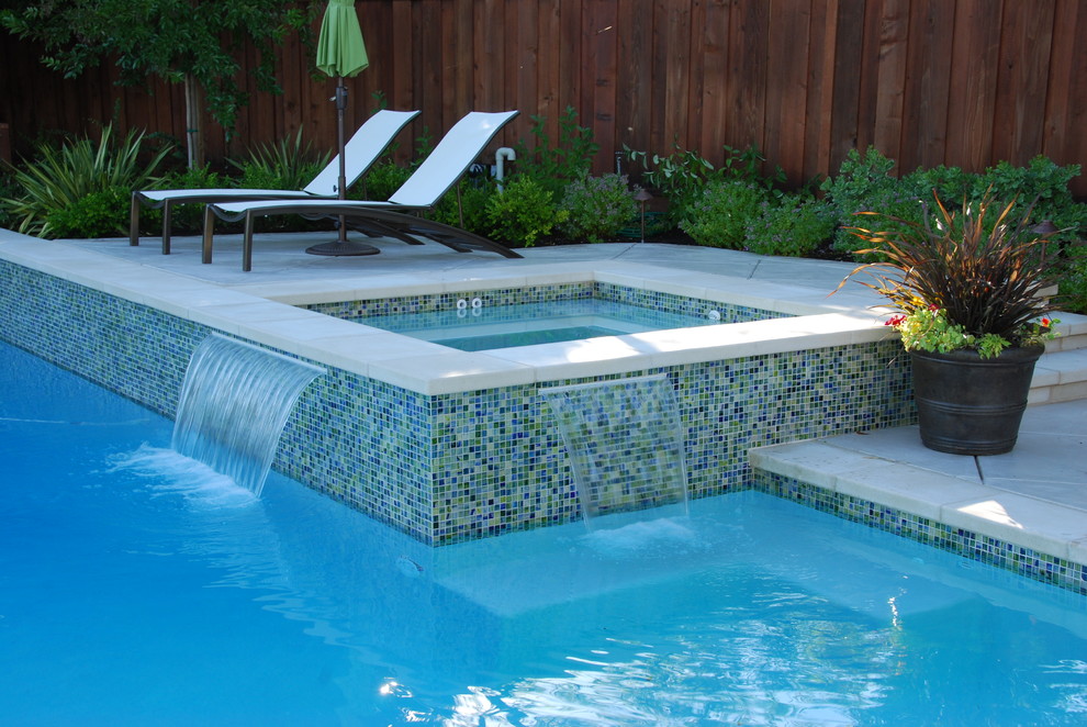 Idées déco pour une grande piscine arrière moderne sur mesure avec un bain bouillonnant et une dalle de béton.