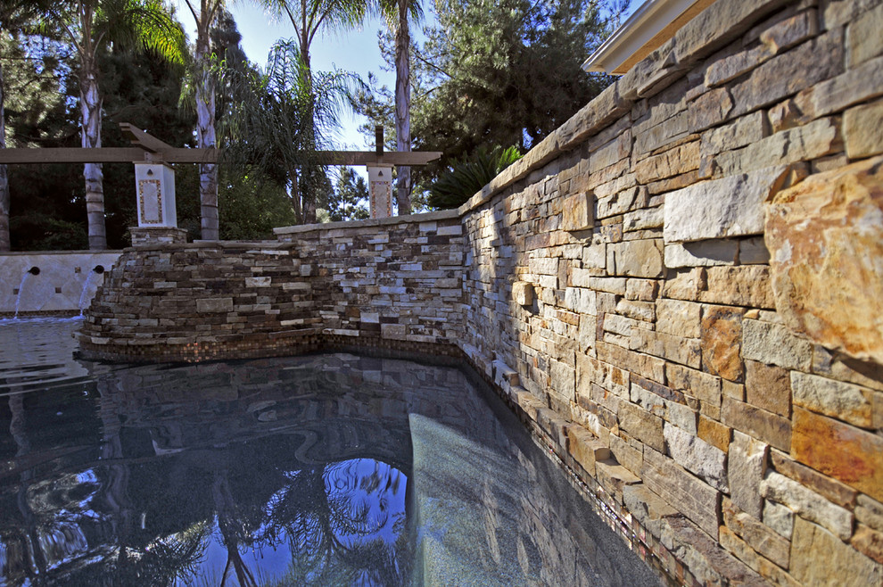 Esempio di una piscina fuori terra mediterranea personalizzata di medie dimensioni e dietro casa con lastre di cemento e una vasca idromassaggio