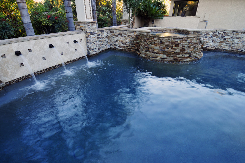 Ispirazione per una piscina fuori terra mediterranea personalizzata di medie dimensioni e dietro casa con lastre di cemento e una vasca idromassaggio