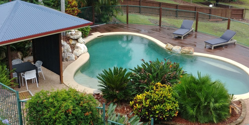 Foto de piscina natural campestre grande tipo riñón en patio trasero con entablado