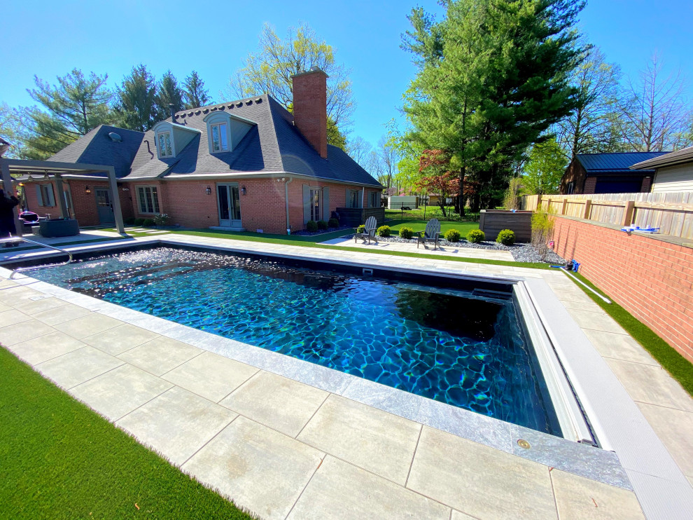 Idee per una grande piscina monocorsia moderna rettangolare dietro casa con fontane e pavimentazioni in cemento