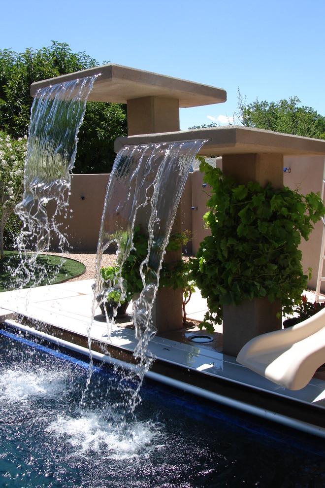 Modelo de piscina retro de tamaño medio rectangular en patio trasero con losas de hormigón
