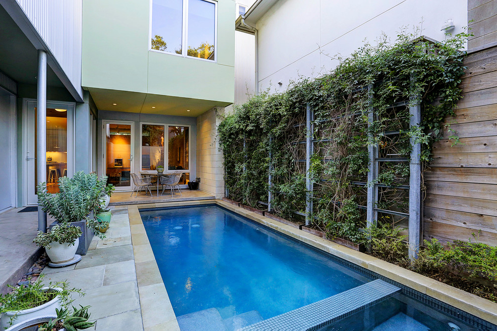 Modelo de piscinas y jacuzzis alargados modernos pequeños rectangulares en patio con adoquines de piedra natural