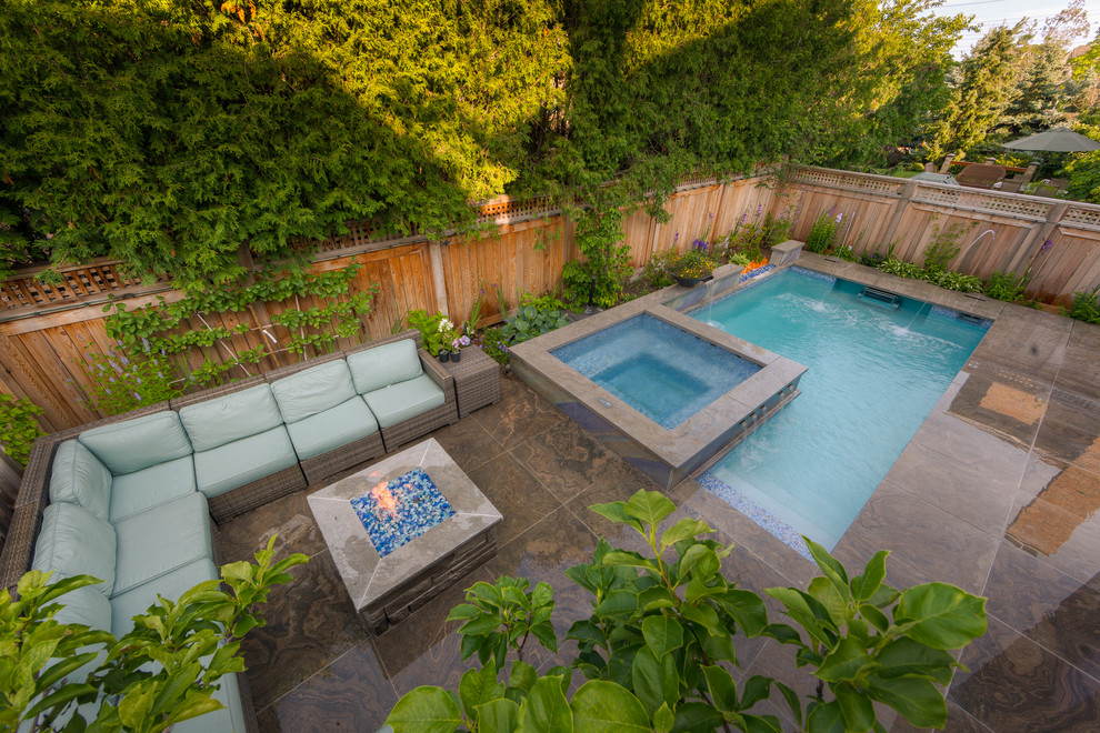 Diseño de piscina con fuente tradicional pequeña rectangular en patio trasero con suelo de hormigón estampado