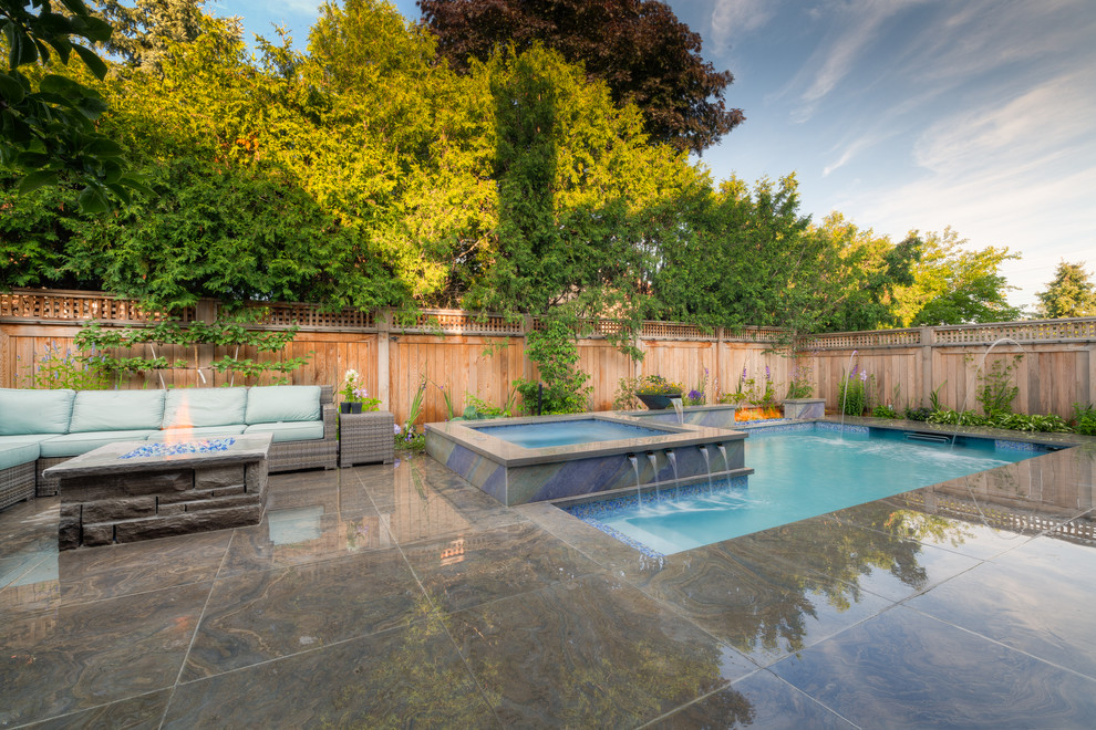 Diseño de piscina con fuente clásica pequeña rectangular en patio trasero con suelo de hormigón estampado