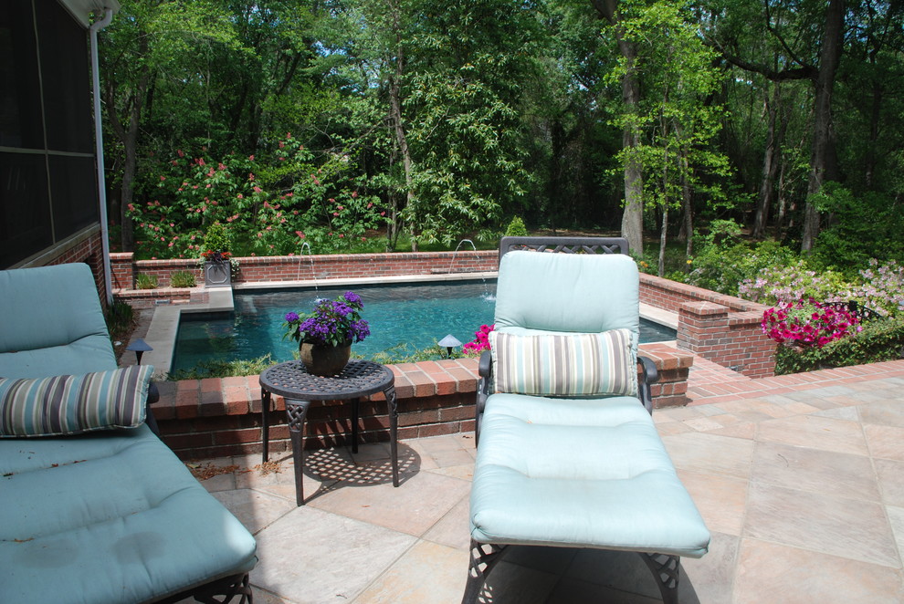 Foto de piscina con fuente actual grande rectangular en patio trasero con adoquines de ladrillo