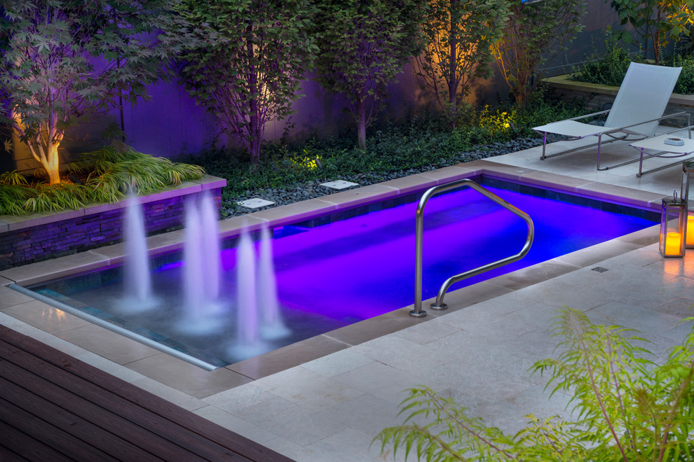 Example of a small classic courtyard stone and rectangular lap pool fountain design in Chicago