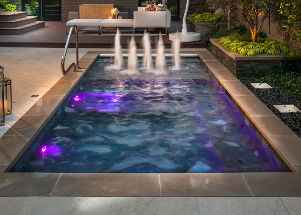 Diseño de piscina con fuente alargada clásica pequeña rectangular en patio con adoquines de piedra natural