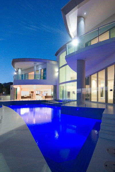 Idee per una grande piscina monocorsia moderna personalizzata dietro casa con piastrelle