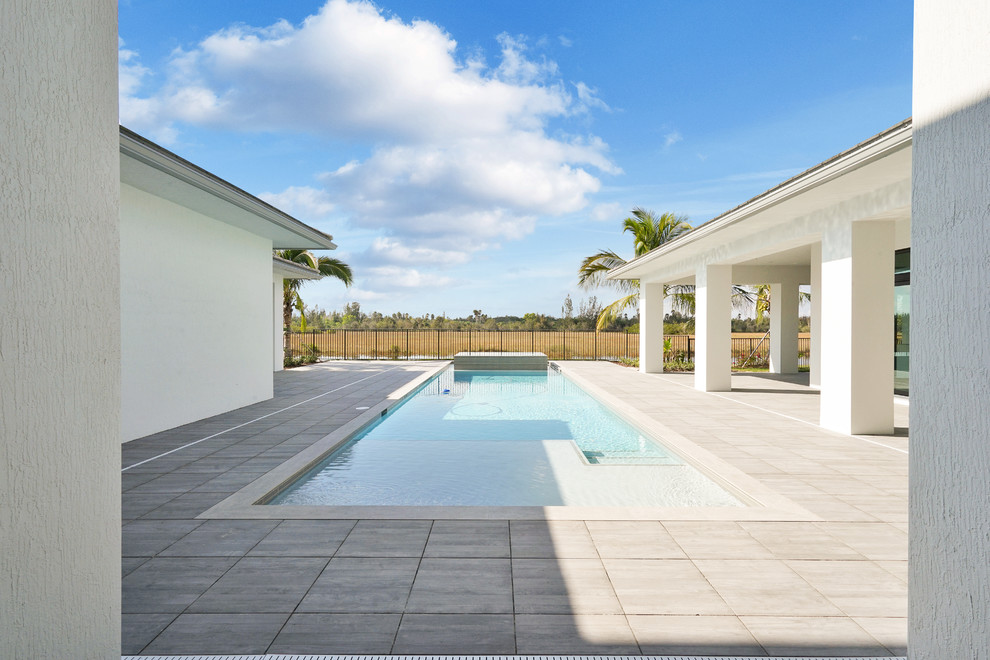 Mittelgroßer Moderner Pool hinter dem Haus in rechteckiger Form mit Natursteinplatten in Miami