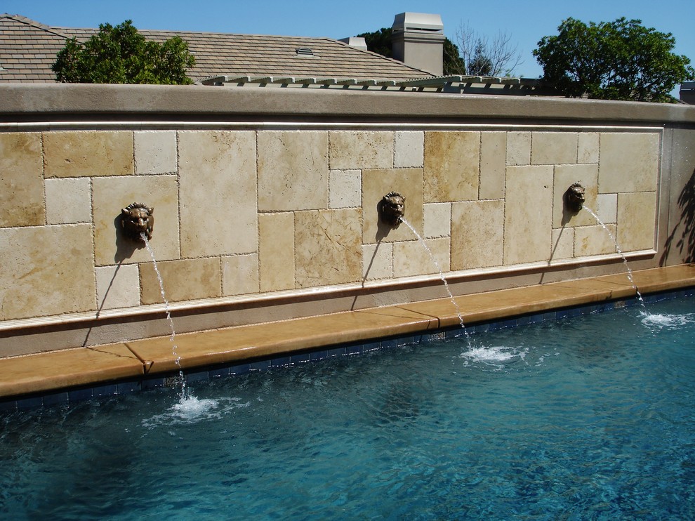 Modelo de piscinas y jacuzzis actuales pequeños rectangulares en patio trasero con suelo de hormigón estampado