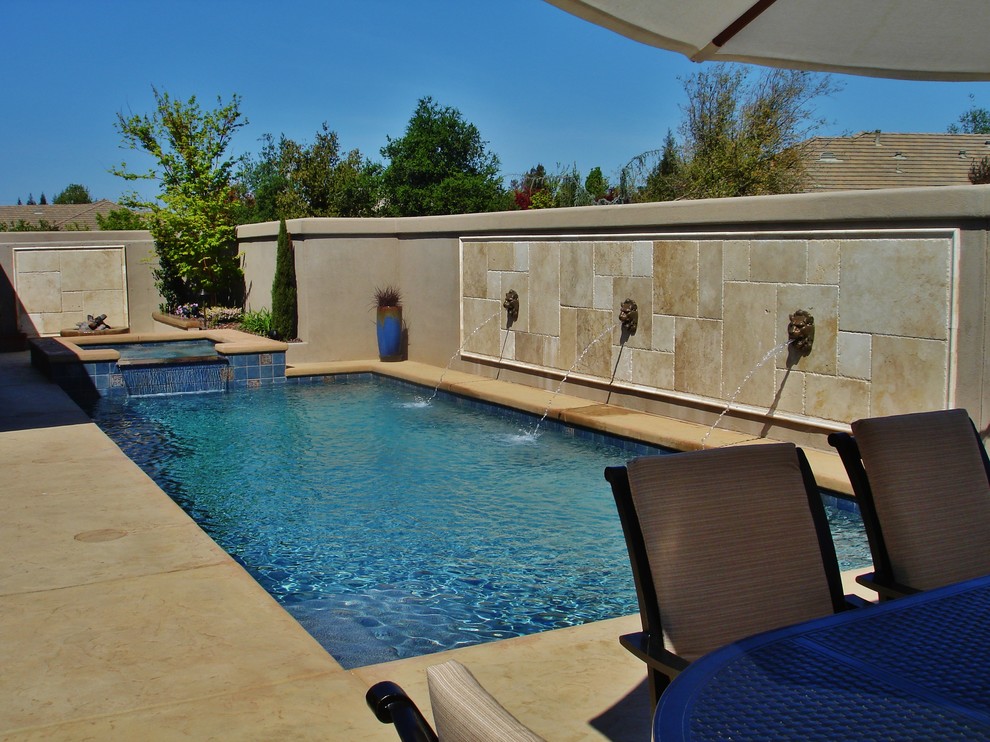 Immagine di una piccola piscina contemporanea rettangolare dietro casa con una vasca idromassaggio e cemento stampato