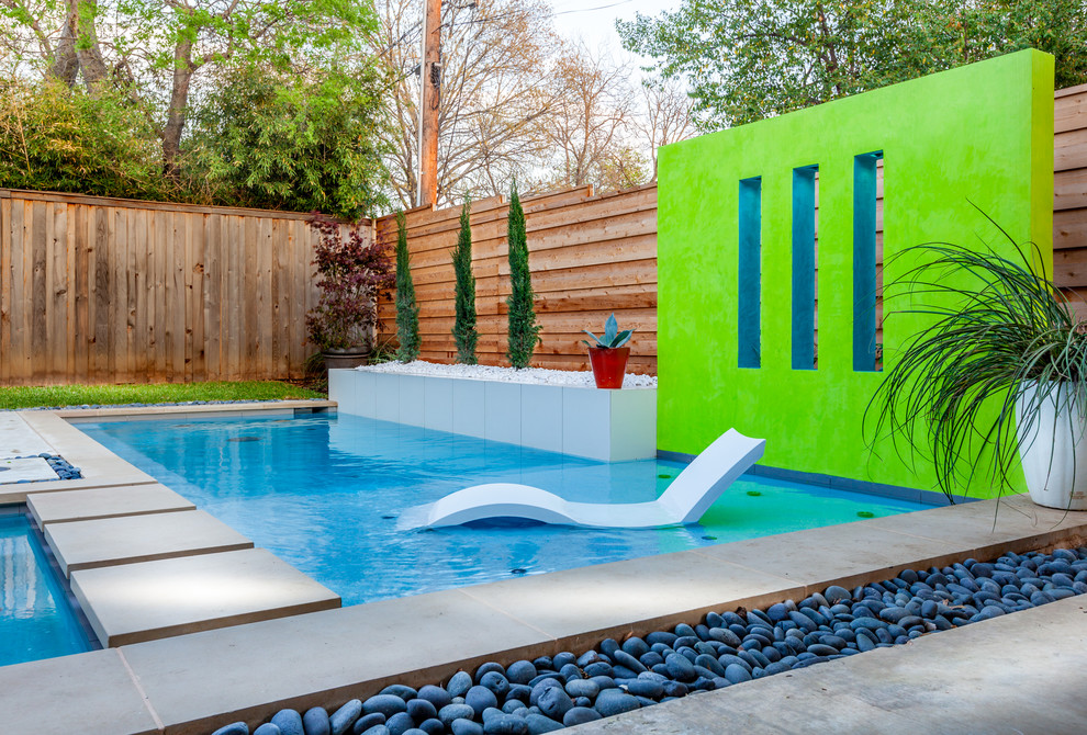 Diseño de piscina minimalista de tamaño medio en forma de L en patio trasero con losas de hormigón