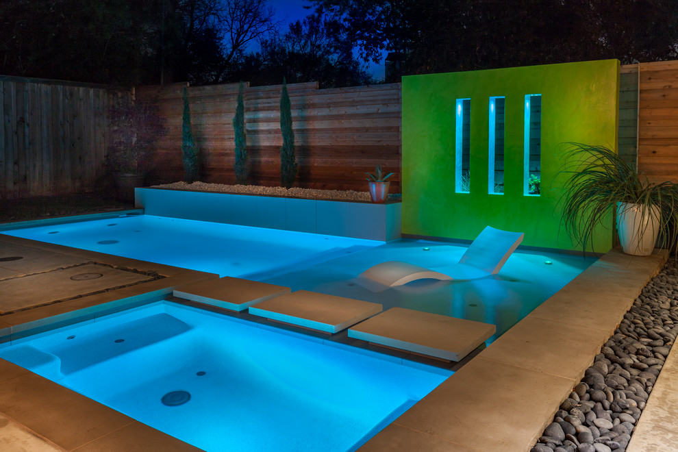 Imagen de piscina contemporánea pequeña en forma de L en patio trasero con adoquines de hormigón