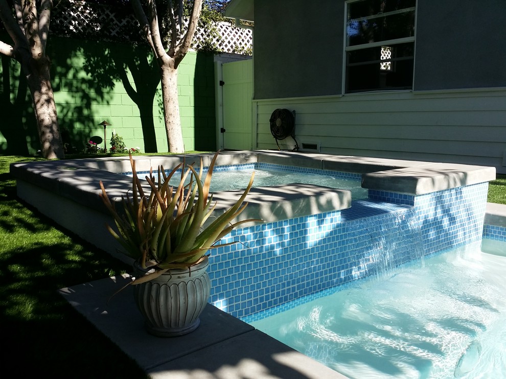 На фото: маленький прямоугольный, естественный бассейн на заднем дворе в современном стиле с джакузи и мощением тротуарной плиткой для на участке и в саду