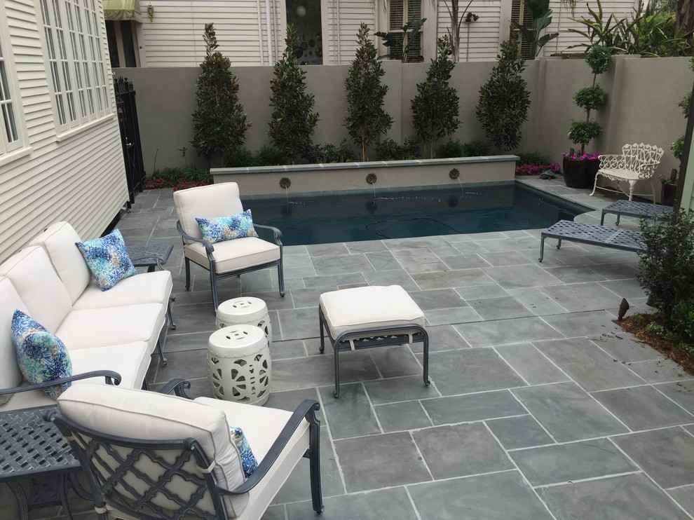 Medium sized classic back rectangular lengths swimming pool in New Orleans with a water feature and natural stone paving.