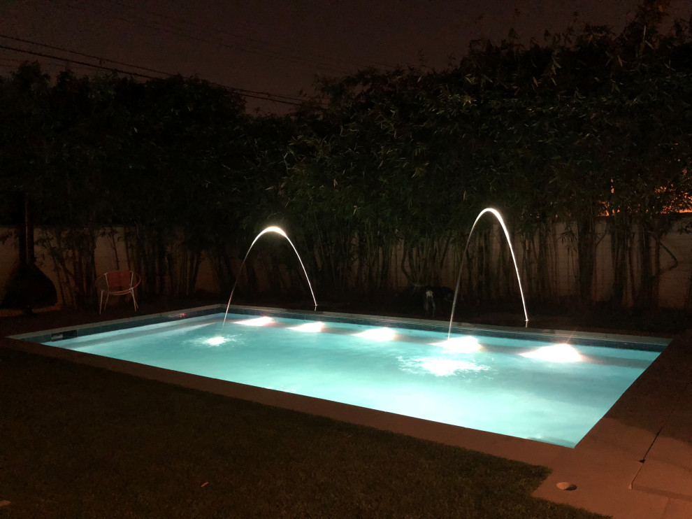 Ispirazione per una piscina contemporanea rettangolare di medie dimensioni e dietro casa con fontane e pedane