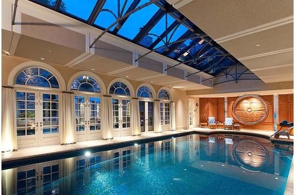 На фото: большой естественный, прямоугольный бассейн в доме в классическом стиле с домиком у бассейна и покрытием из бетонных плит с