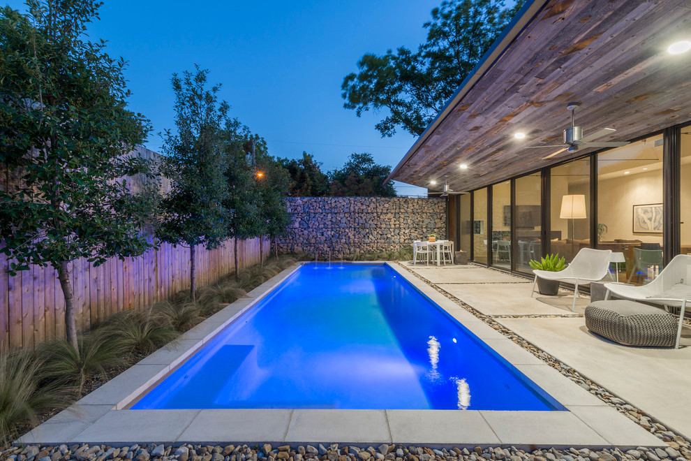 Moderner Pool hinter dem Haus in rechteckiger Form mit Wasserspiel in Dallas