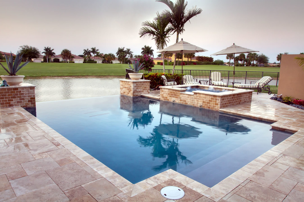 Diseño de piscinas y jacuzzis infinitos exóticos de tamaño medio a medida en patio trasero con suelo de baldosas