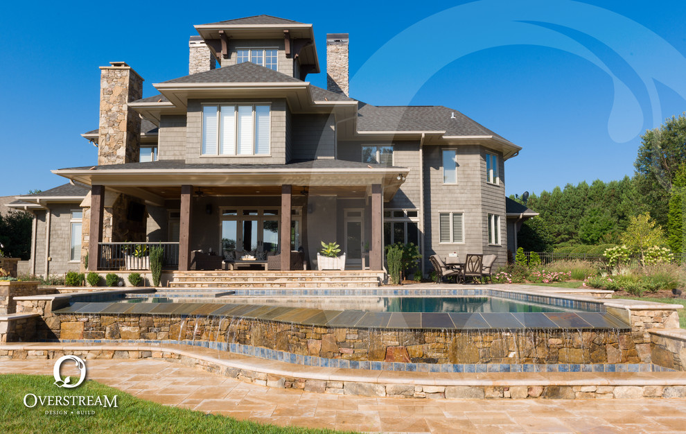 Ispirazione per una grande piscina a sfioro infinito moderna personalizzata dietro casa con una vasca idromassaggio e pavimentazioni in pietra naturale