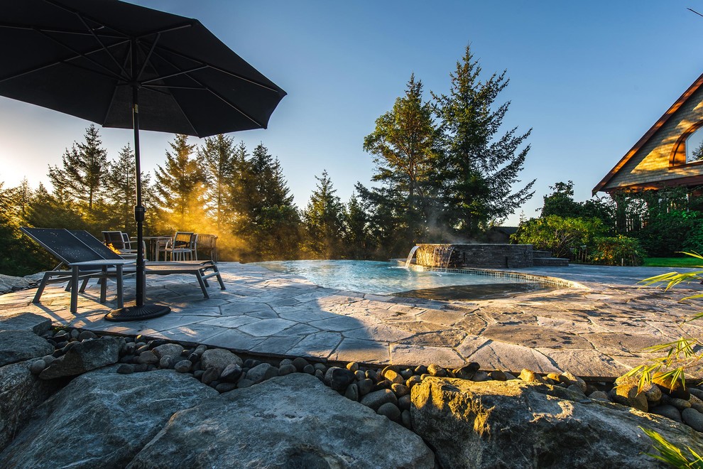 Imagen de piscinas y jacuzzis infinitos de estilo americano grandes a medida en patio delantero con adoquines de piedra natural