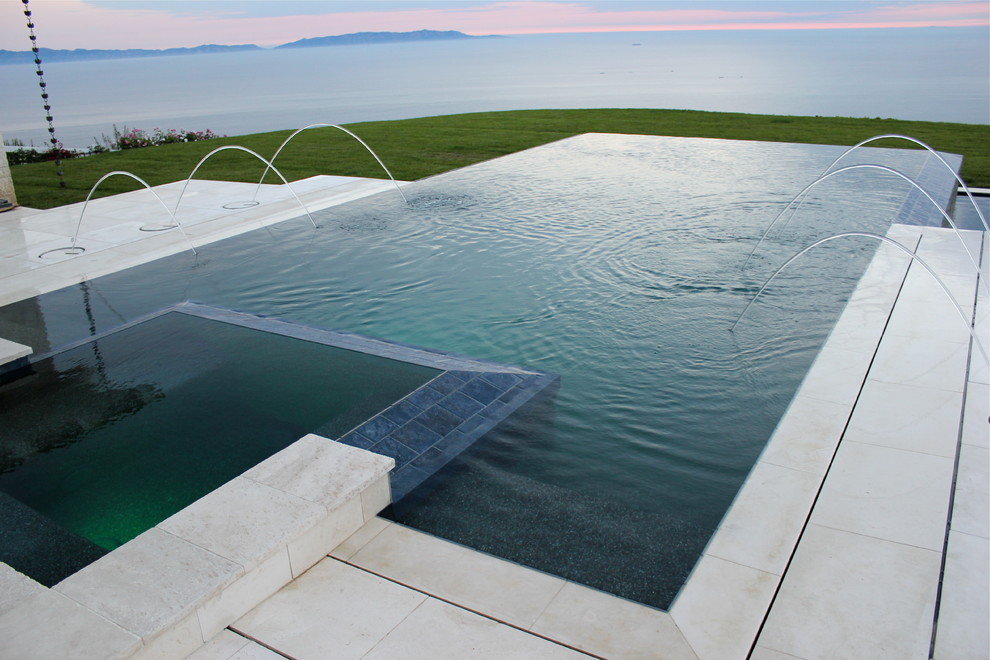 Свежая идея для дизайна: прямоугольный бассейн-инфинити среднего размера на заднем дворе в современном стиле с джакузи и покрытием из плитки - отличное фото интерьера