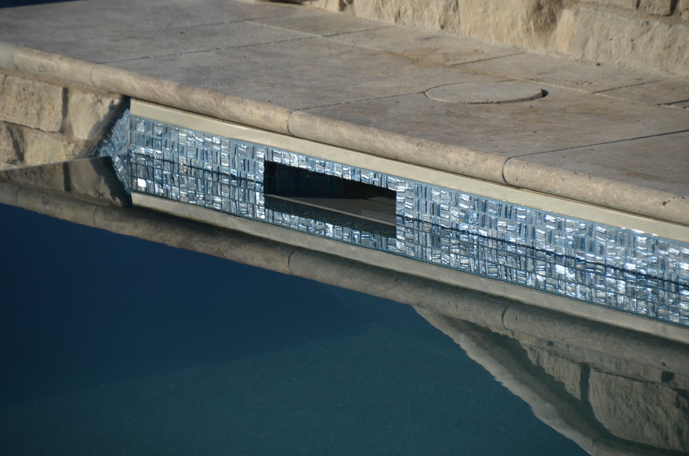 Großer Moderner Infinity-Pool hinter dem Haus in rechteckiger Form mit Natursteinplatten in Sonstige