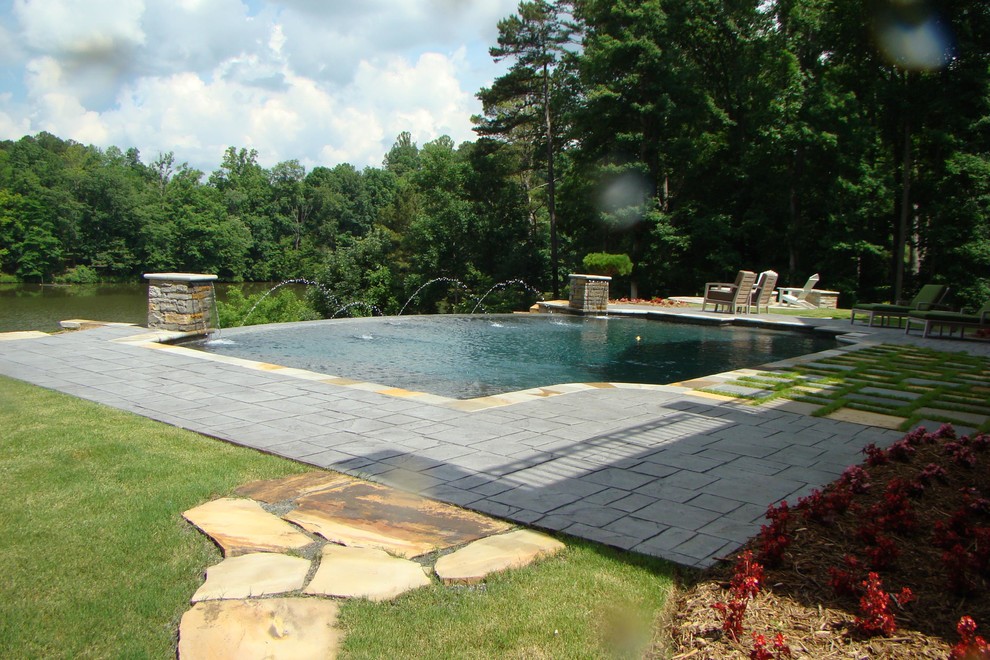 Design ideas for a traditional back rectangular infinity swimming pool in Atlanta with a water feature.