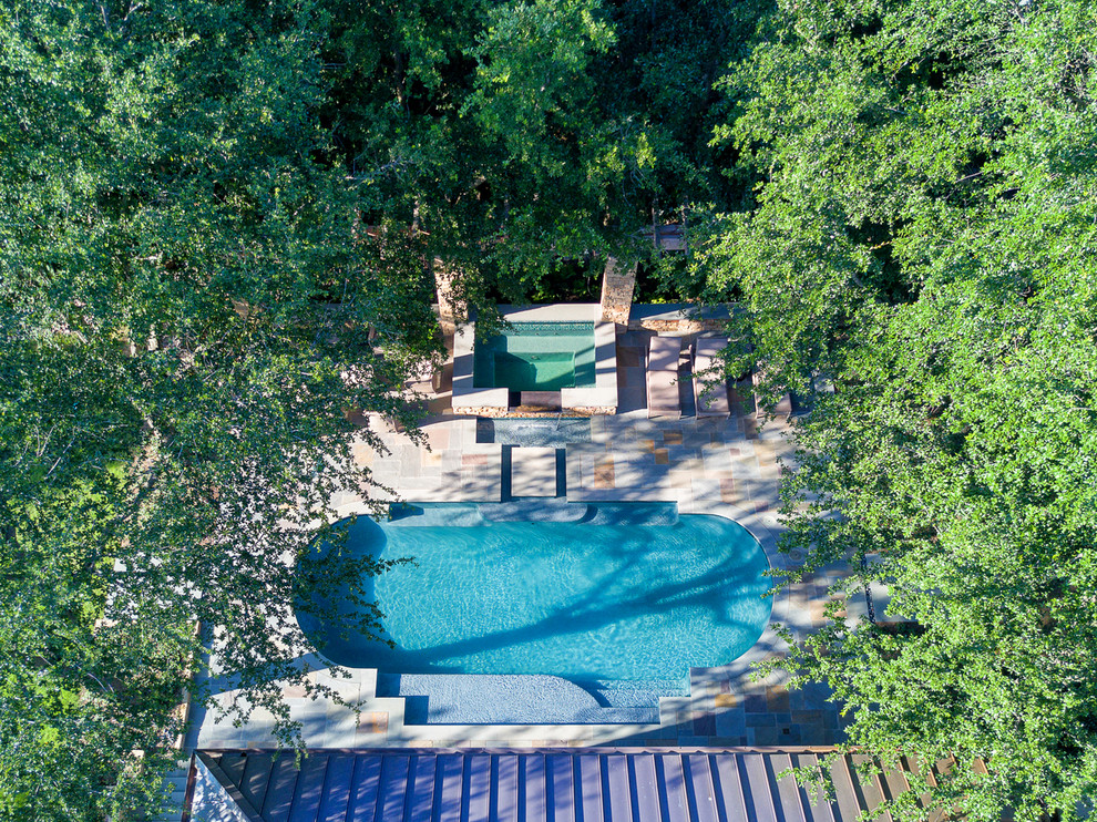 Cette photo montre une grande piscine arrière chic sur mesure avec une terrasse en bois.