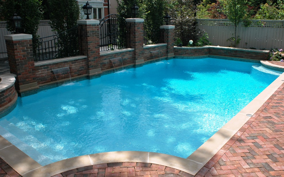 Design ideas for a large mediterranean back custom shaped swimming pool in Other with a water feature and brick paving.